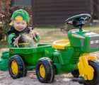 Kid playing with Kettler John Deere 3-wheeled pedal tractor with trailer