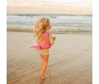 Girl wearing Sunnylife Ocean Treasure Rose Float Vest on the beach