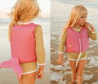 Girl wearing Sunnylife Ocean Treasure Rose Float Vest on the beach