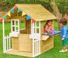 Two children playing with TP Toys Bakewell Wooden Playhouse outside in the yard. Available from tenlittle.com