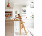 Child standing on Piccalio Foldable Kitchen Tower in natural in the kitchen next to countertop. Available from tenlittle.com
