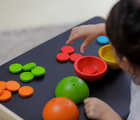 Child playing with PlanToys Sort & Count Cups. Available from tenlittle.com