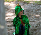 Child wearing Little Adventures Dragon Cloak costume in the park. Available from tenlittle.com