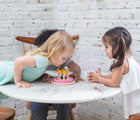 Three kids playing with PlanToys Birthday Cake Set on a table. Available from tenlittle.com