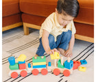 Child playing with Melissa & Doug Stacking Train on the floor. Available from tenlittle.com