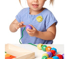 Child playing with Melissa & Doug Primary Lacing Beads. Available from tenlittle.com