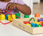 Child playing with Melissa & Doug Primary Lacing Beads. Available from tenlittle.com