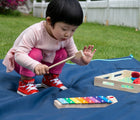Chid playing with xylophone from Melissa & Doug Band in a Box - Hum, Jangle, Shake. Available from tenlittle.com