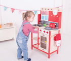 Girl playing with Bigjigs Play Kitchen. Available from www.tenlittle.com.