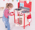 Girl playing with Bigjigs Play Kitchen. Available from www.tenlittle.com.