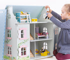 Girl playing with Bigjigs Ivy House Dollhouse. Available from www.tenlittle.com.